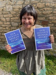 Author Doina Cornell holds her book Our Ocean's Broken Heart
